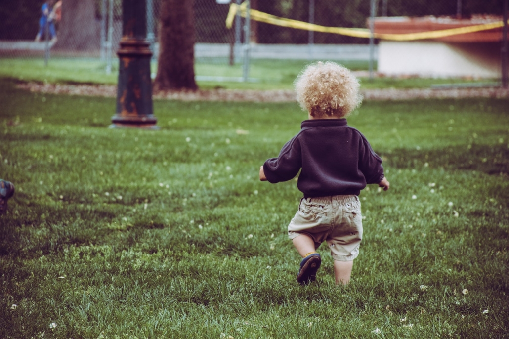 Kleines Kind läuft im Gras.